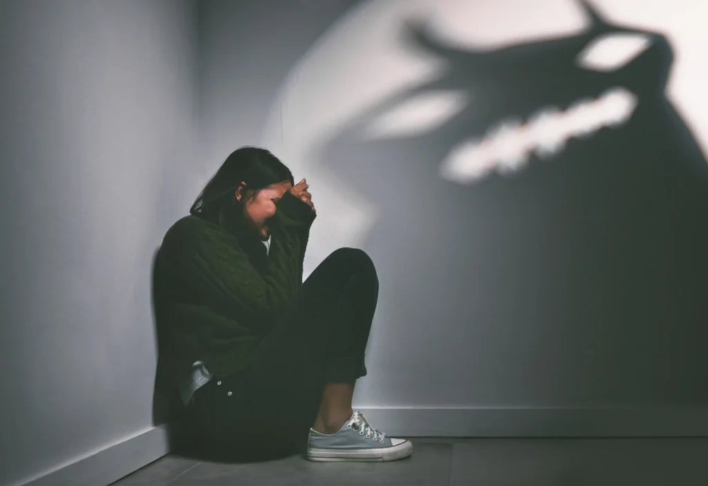 shot of a young woman sitting in the corner of a d
